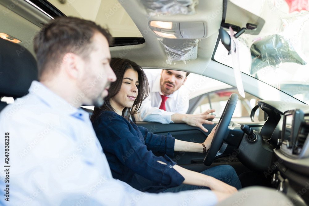 Female Customer Examining Car Interiors With Boyfriend Female Customer Examining Car Interiors With Boyfriend