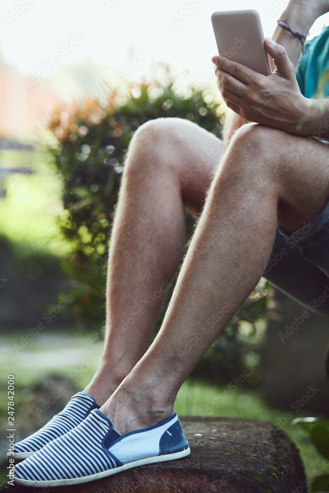 Obraz premium Modern man using cellphone outdoors.