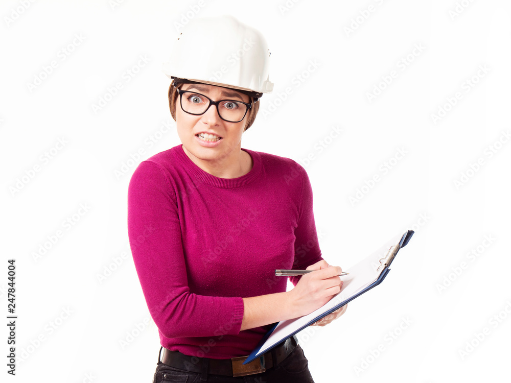 Fototapeta premium Emotional girl brigadier in a white helmet with glasses and a folder in his hands on a white background