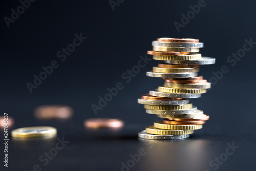 Coins stacked on each other in different positions on a black background