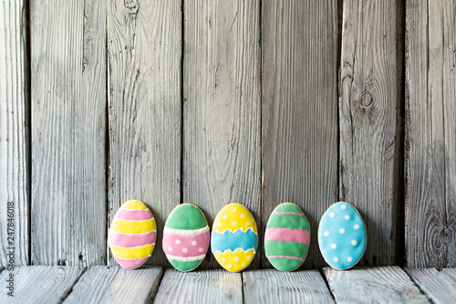 Easter eggs on a wooden background, iced biscuits