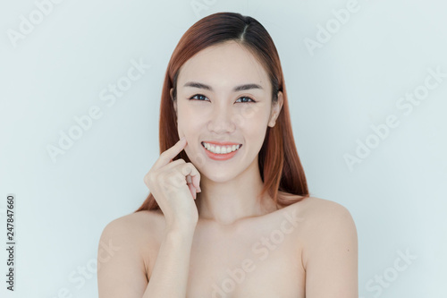 Pretty Asian girl with big eyes and dark eyebrows, with naked shoulders, beautiful woman looking at camera and smiling