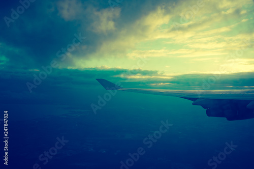 Wing of an airplane flying in the clouds. © Iri-s