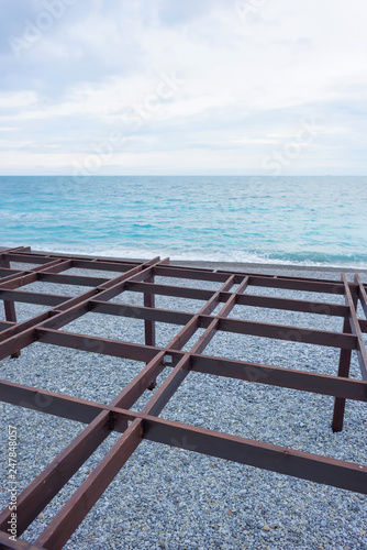 Metal structures on the beach. Canopy. Black Sea. Rocky beach. Water surface. Massandra beach. Yalta. Rest in Crimea. Walk along the beach. photo