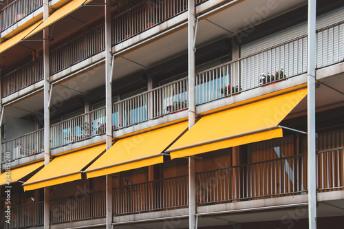 Nice balcony with yellow awning in apartment house. photo