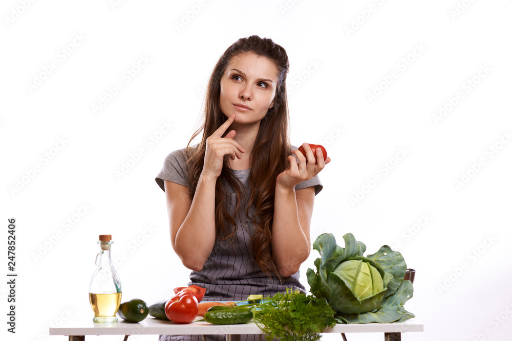 happy adult woman with various fresh vegetables on kitchen table looking at camera happy adult woman with various fresh vegetables on kitchen table looking at camera