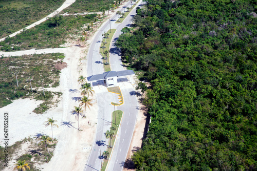 View from above. The road  the checkpoint divides the territory of Punta Cana  the Dominican Republic into two parts  a national park and the coast with sand and palm trees. Contrast.