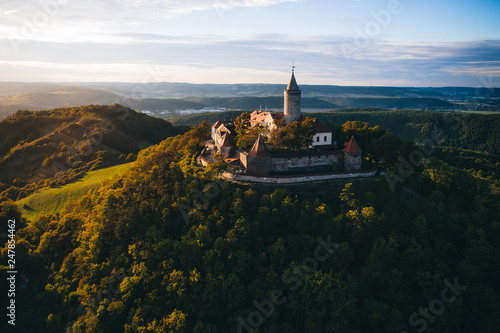 Ein Schloss in Deutschland im Sonnenuntergang auf einem Berg mit Bäumen