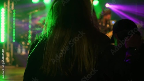 Rock concert in Germany. A fan with beautiful long hair dances at the stage of his favorite band.