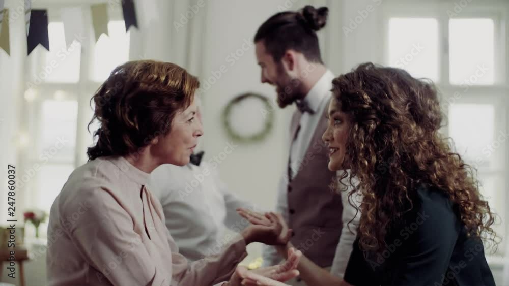 Young couple greeting parents or grandparents on a indoor birthday party. Young couple greeting parents or grandparents on a indoor birthday party.