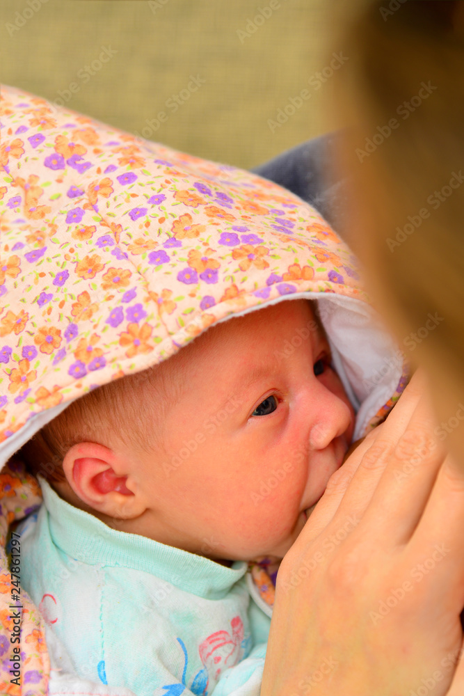 Mother covers her breasts with her hand when the baby eats milk. Mother covers her breasts with her hand when the baby eats milk.