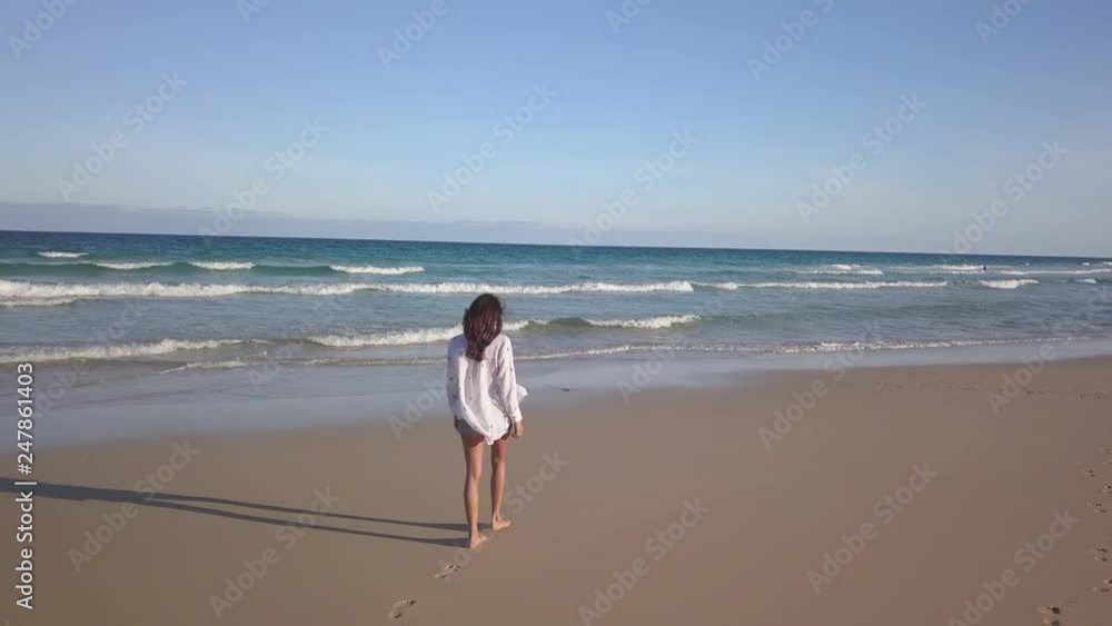 girl walking alone on the beach girl walking alone on the beach
