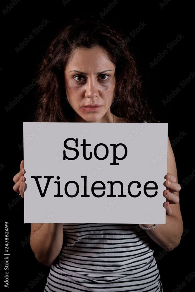 Stop violence message from a scared woman with bruises and wounds marks on her face after a case of gender violence in a young couple Stop violence message from a scared woman with bruises and wounds marks on her face after a case of gender violence in a young couple