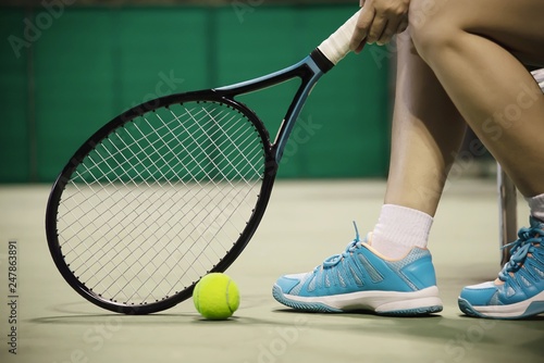 Lady tennis player sitting in the court during game break - people in sport tennis game concept