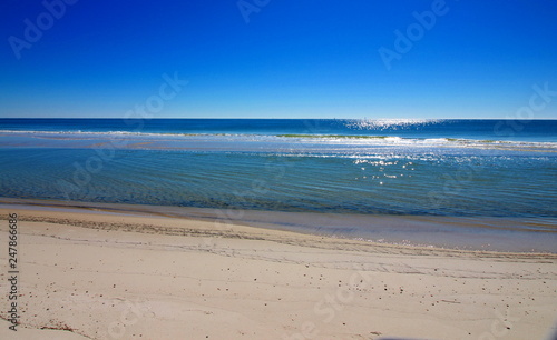 Gulf Shores beach in Alabama, the sunlight is reflecting off of the surf