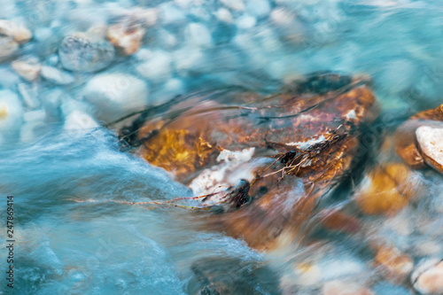 rocks and stones wrapped by the flowing of the turquoise water of the river