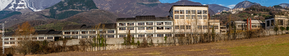 wide panorama of abandoned chemical product factory against the background of the Marsicani mountain range
