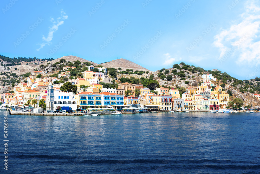 Bell-tower and colorful neoclassical houses in harbor town of Symi (Symi Island, Greece)