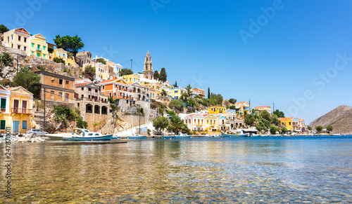 Anchored boats and colorful neoclassical houses in bay of Symi (Symi Island, Greece)