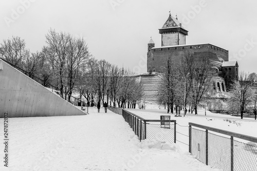 Narva River Promenade, Narva castle and river on a snowy winter day. Black and white. photo