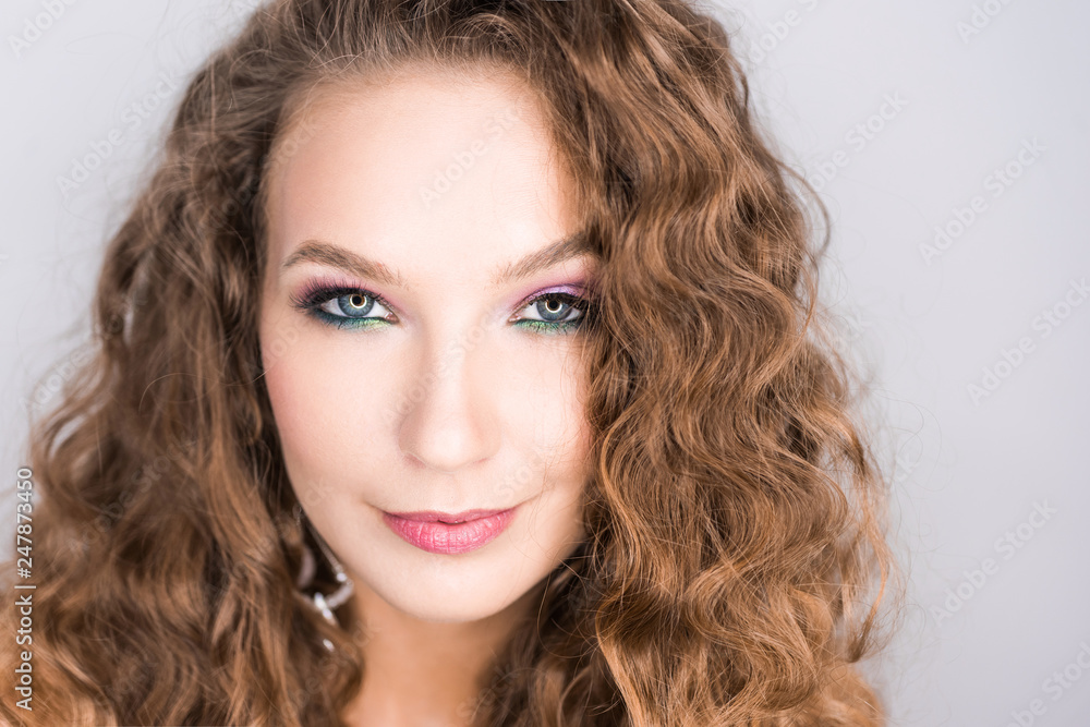 portrait beautiful young blonde curly girl posing in the studio with professional make-up and open tooth smile pink mood portrait beautiful young blonde curly girl posing in the studio with professional make-up and open tooth smile pink mood