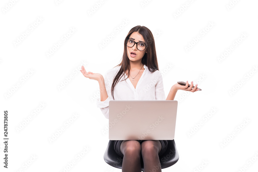 Shocked businesswoman. Surprised young woman in shirt with laptop and phone looking at camera and keep her mouth open while standing on white background Shocked businesswoman. Surprised young woman in shirt with laptop and phone looking at camera and keep her mouth open while standing on white background