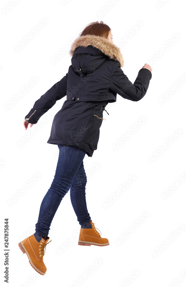 Naklejka premium back view of running woman in winter jacket.