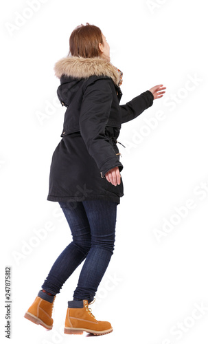 back view of running woman in winter jacket.