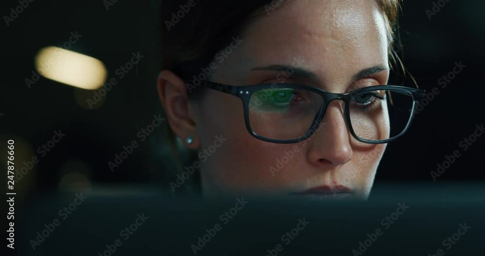 Slow motion of a young beautiful business woman wearing glasses working with a computer in a office. Shot in 8K. Concept of technology, business and finance, economy, management, success Slow motion of a young beautiful business woman wearing glasses working with a computer in a office. Shot in 8K. Concept of technology, business and finance, economy, management, success