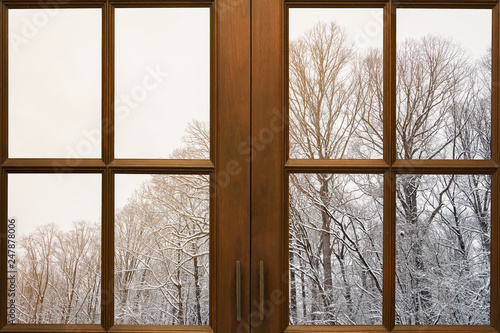 Old wooden window frame with winter view from outside.