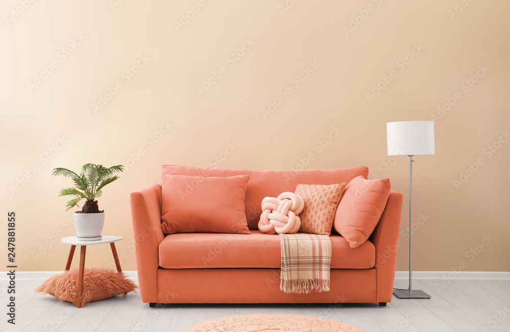 Simple living room interior with modern sofa near color wall. Space for text