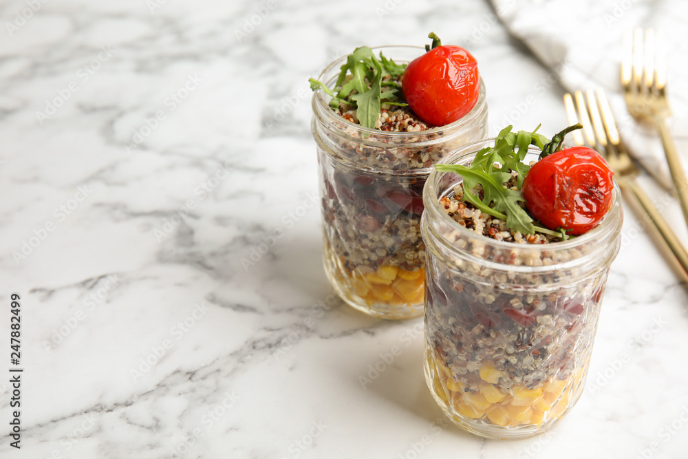 Healthy quinoa salad with vegetables in jars on table. Space for text Healthy quinoa salad with vegetables in jars on table. Space for text