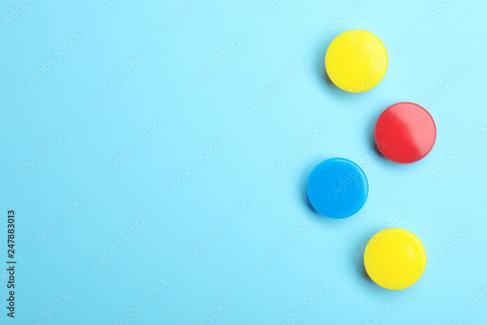 Bright magnets on color background, top view with space for text