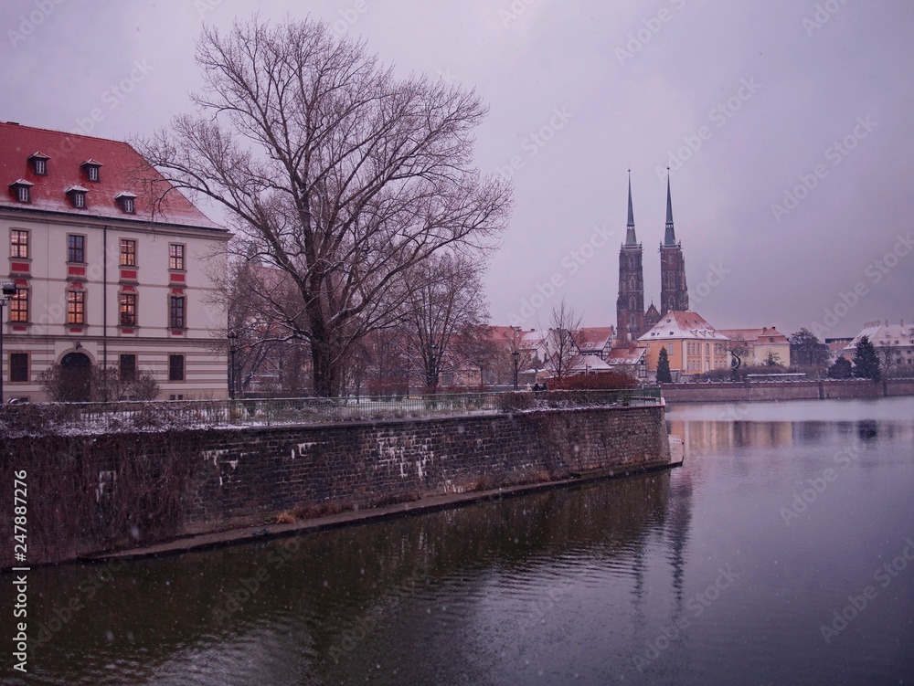 Fototapeta View of Odra or Oder River, Ostrow Tumski and St. John the Baptist Cathedral on a Wintry Snowy Day