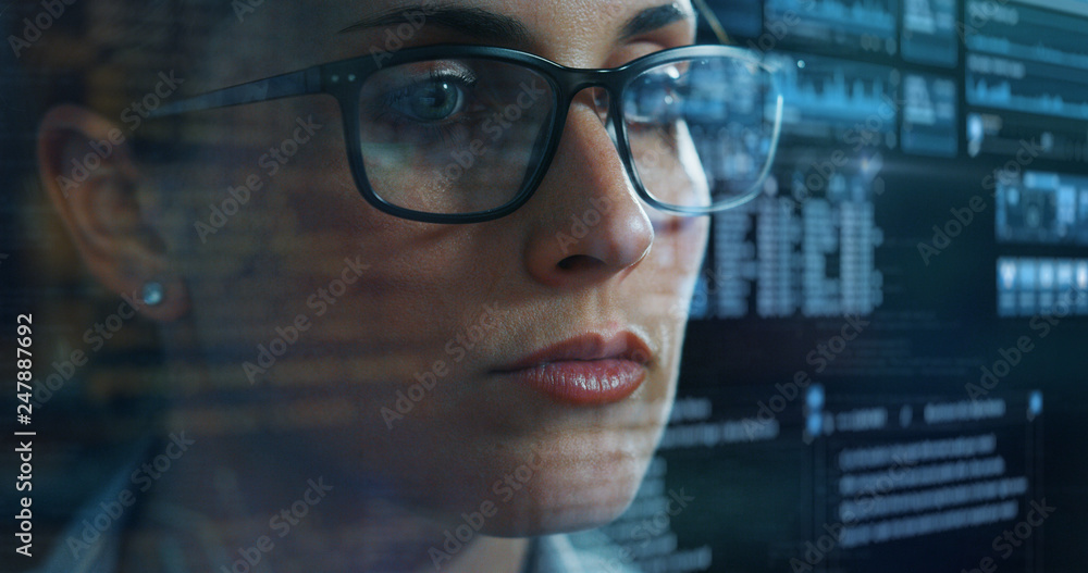 Portrait of a young beautiful business woman reading financial news about the world economy on a futuristic holographic screen in a office. Concept of future technology, business and finance Portrait of a young beautiful business woman reading financial news about the world economy on a futuristic holographic screen in a office. Concept of future technology, business and finance