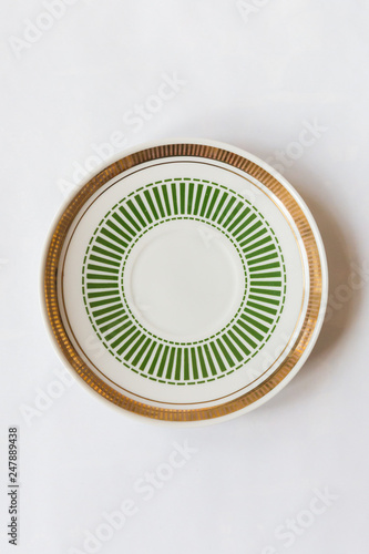 a white round plate with floral and line pattern on white background