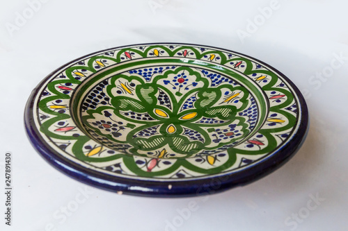 a white round plate with floral and line pattern on white background