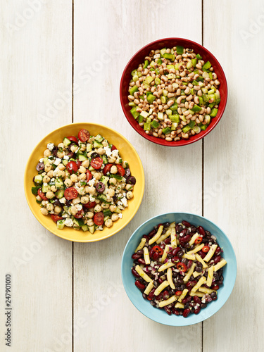 Three different bean salads on a rustic white background photo