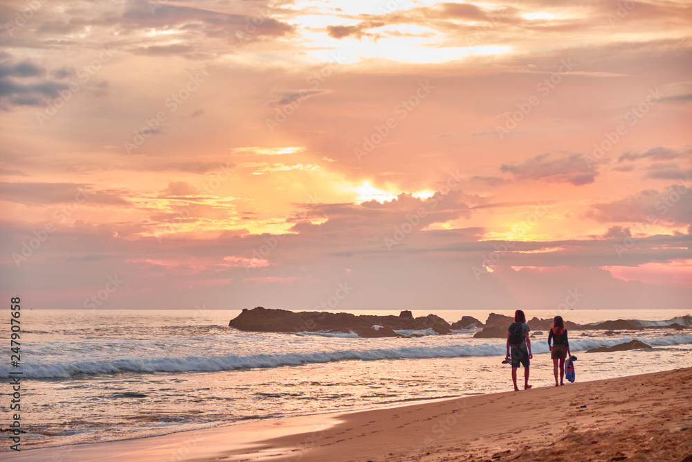 Stunning sunset on the beach overlooking the ocean and the waves. 