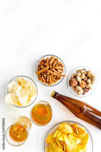 Snacks and beer. Chips, nuts, rusks near beer on white background top view space for text