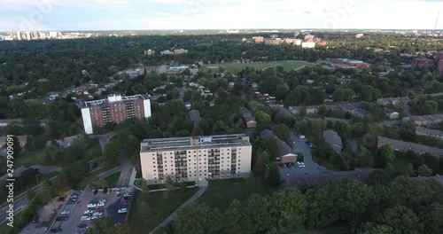 Flying Towards Two Apartment Buildings At Dusk With Field In Distance photo