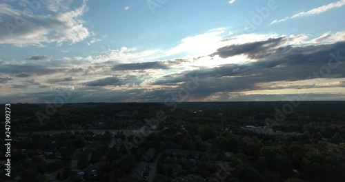 Flying Backwards Over Neighbourhood Dusk With Clouds In Sky photo