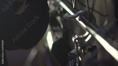 Light technician attaches the spotlight screw to the base of the stage to illuminate hall. work backstage