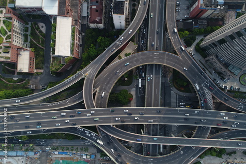 Aerial top down view on busy multilevel interchange overpass in Shanghai showing afternoon traffic coming from the elevated roads. May 14, 2017, Shanghai, China.