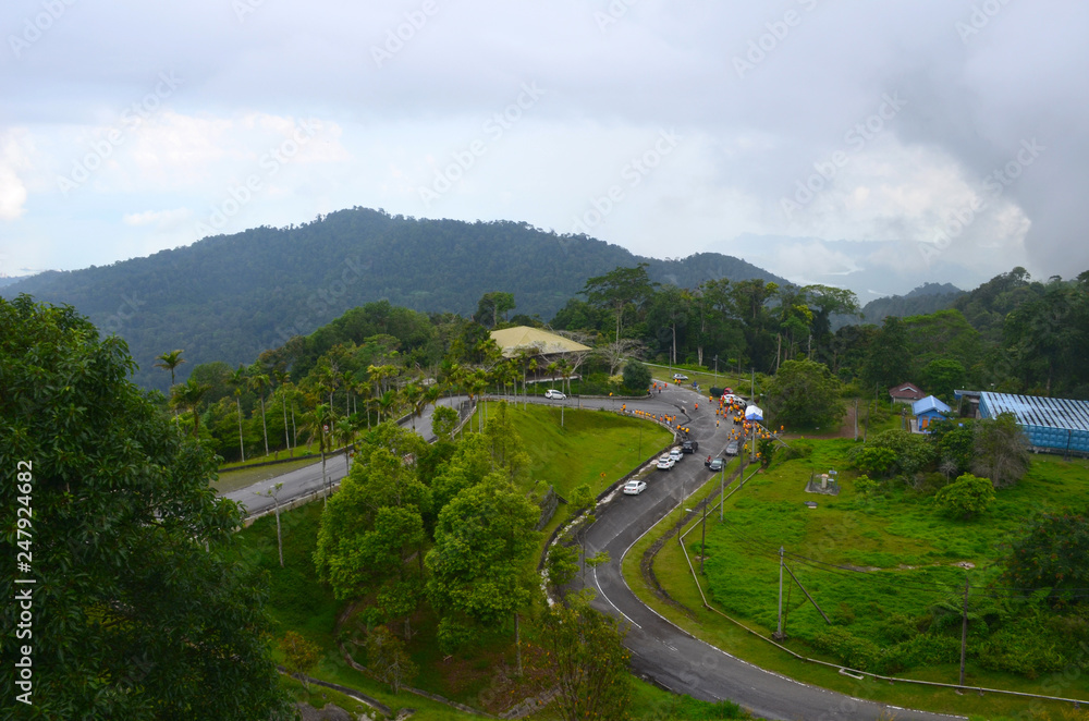 Top view from Gunung Raya mountain to road and sportsman ready for running race, Langkawi island, Malaysia