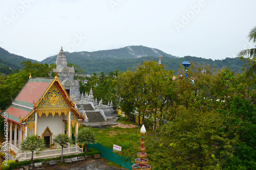 Wat Chalong Temple, Phuket, Thailand. Top view on pagoda and buildings of temple on the background of green mountains. © Irina Kulikova