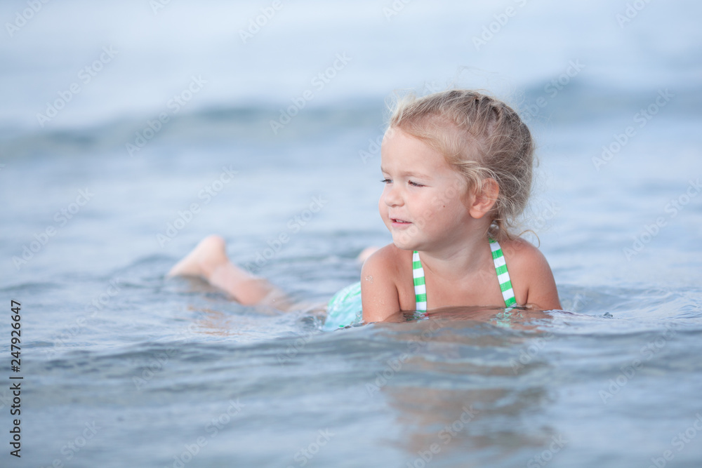 Little cute happy girl swims in the sea, Spain Little cute happy girl swims in the sea, Spain
