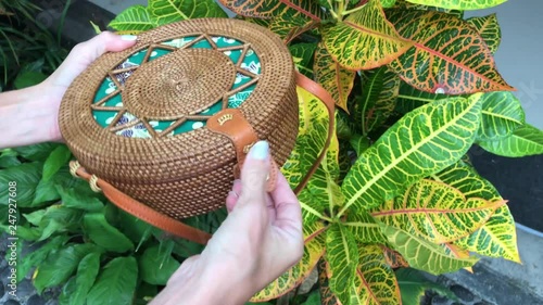 Closeup of stylish handmade rattan handbag on a tropical background. Bali island. photo