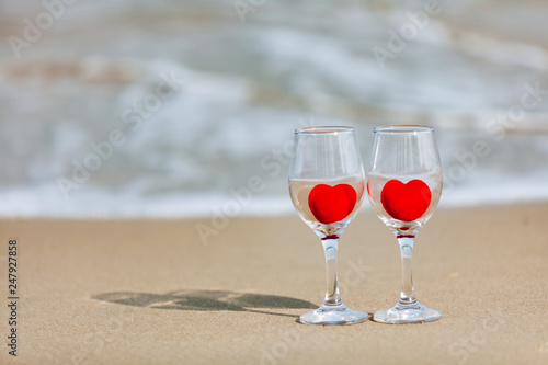 glass of red heart wine on the beach