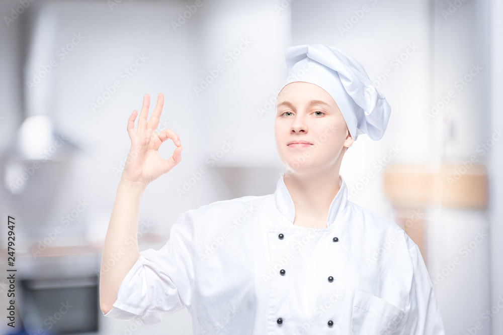 female chef showing hand gesture, satisfied portrait on the background of the kitchen female chef showing hand gesture, satisfied portrait on the background of the kitchen